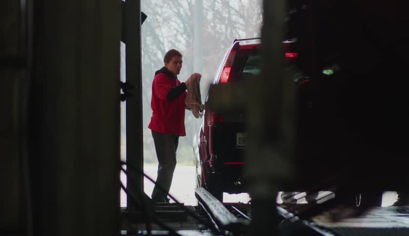 A male employee wiping down a car at a carwash