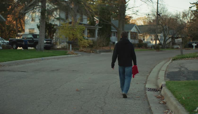 Young man leisurely walking on the neighborhood streets at evening