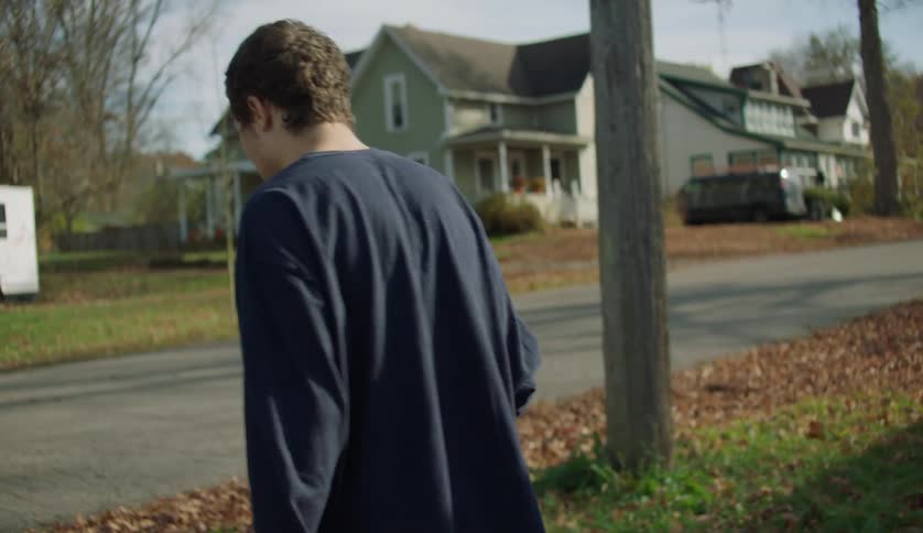 Young man with special needs walking down the street of the neighborhood
