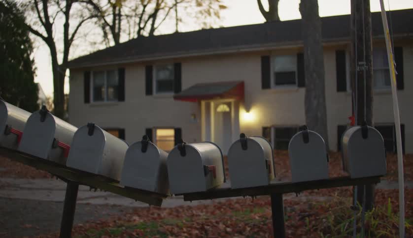 A row of mailboxes in front of a building in the evening