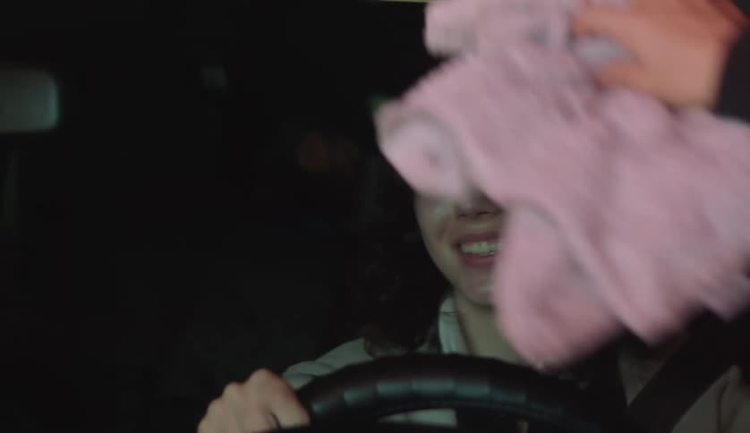 A woman is nervous as someone washes her windshield