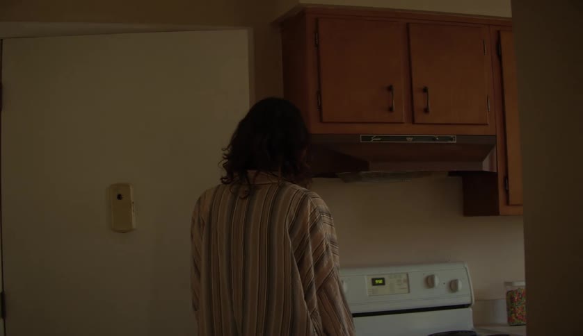 Young attractive woman exits through the door after some hesitation