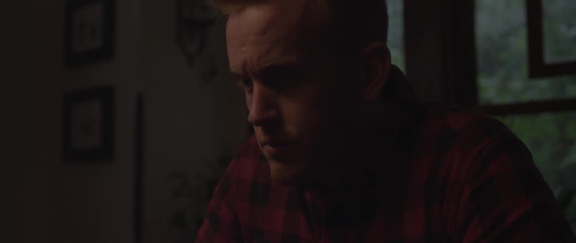 A man is looking down in a dark room