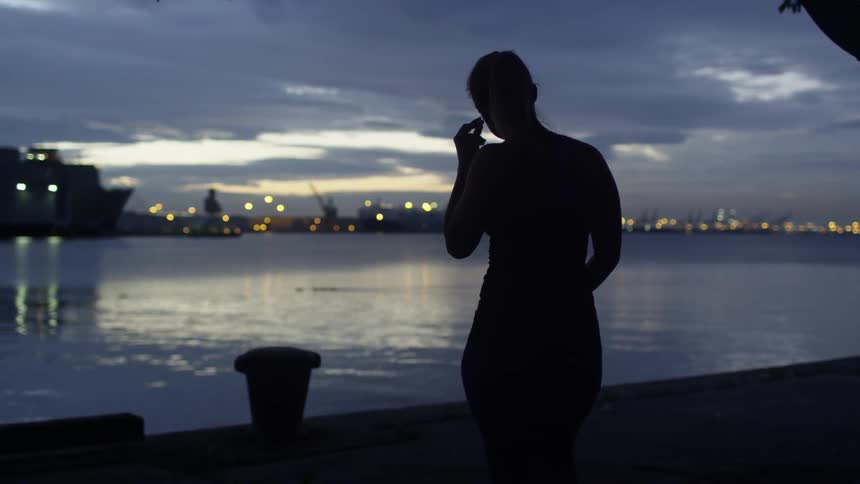 A woman walks to the water at dawn