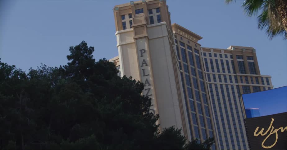 An electronic sign sits outside a large hotel
