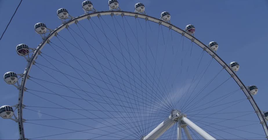 A large ferris wheel spins in the sky