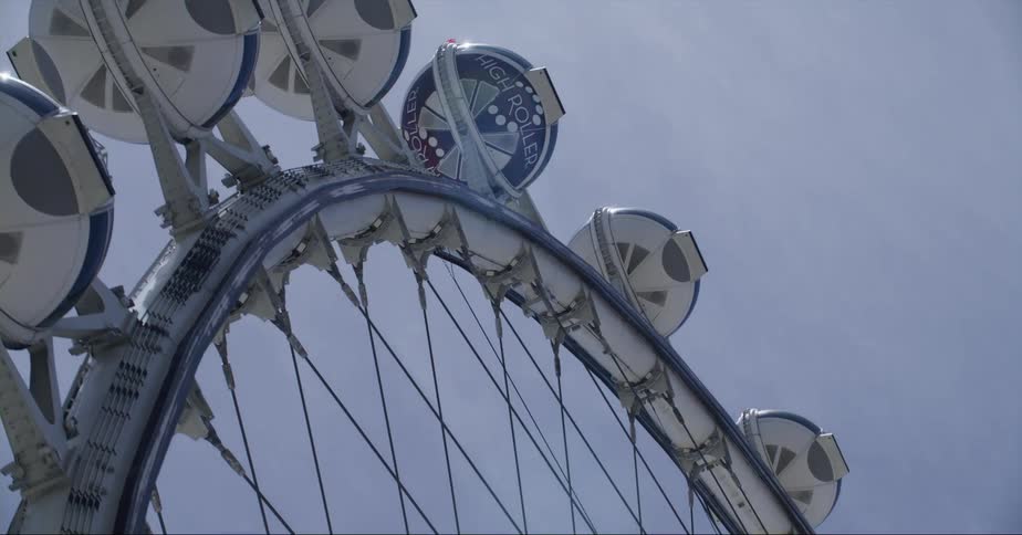 Round gondolas line a large ferris wheel