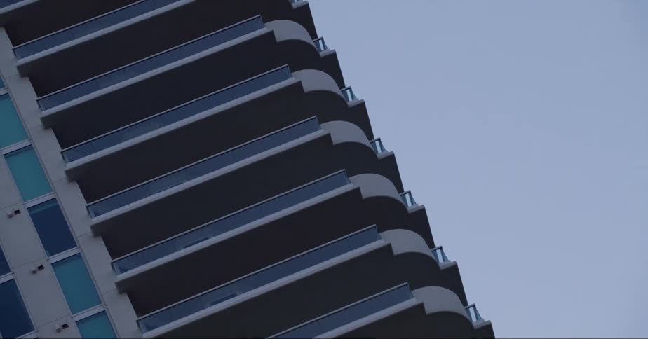 Balconies cover sides of building under a clear sky