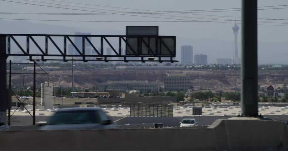 Traffic drives along controlled access highway with foggy skyline in the background