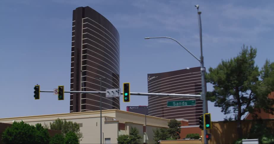 Bus turns at intersection near enclosed pedestrian bridge