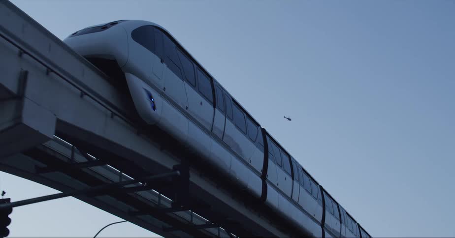 A public passenger rail traveling over a bridge in a city