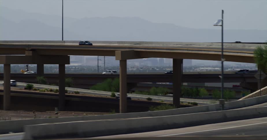 Vehicles driving on the highway overpass near the skyline of las vegas