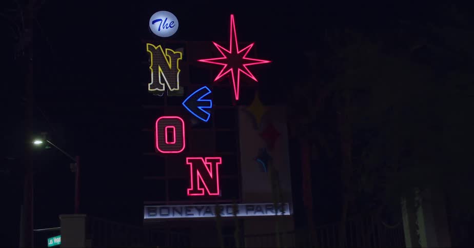 A large flashing neon sign is in the city