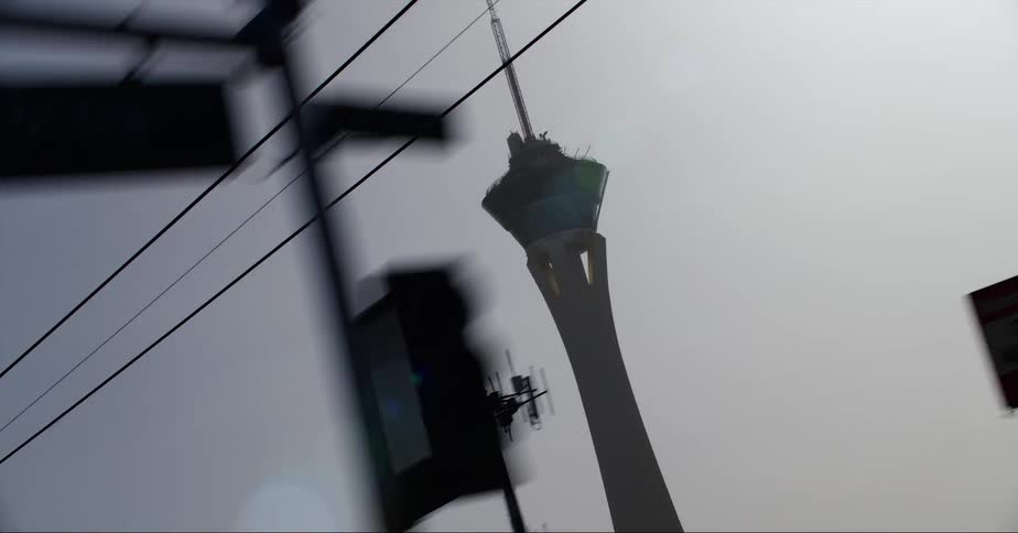 A tower looms over a city during the day