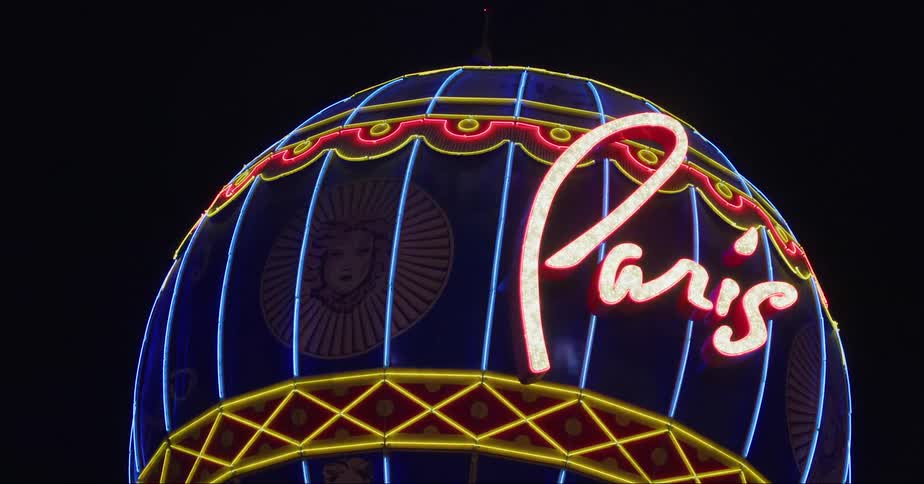 Balloon at paris las vegas glows with neon lights and contrasts against night sky