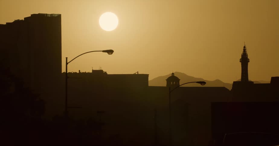 Buildings are silhouetted against the shining sun in the city