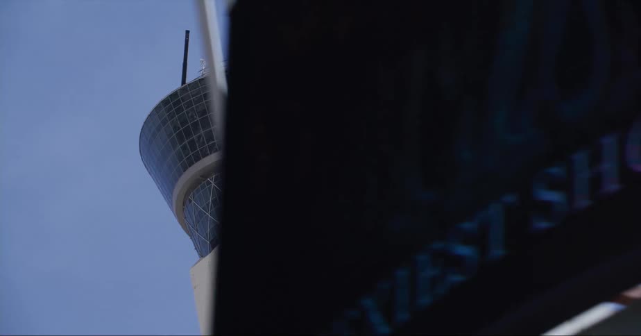 Space needle towers over slightly arched structure with sign