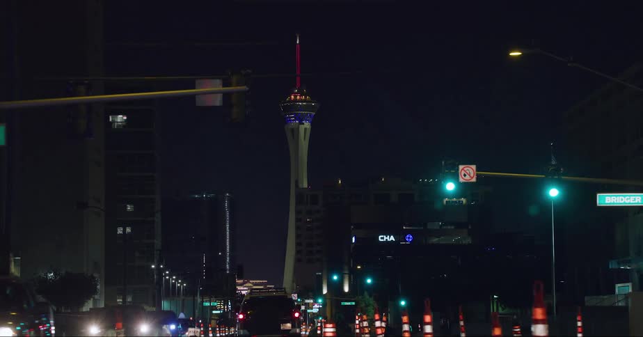 Illuminated strat tower and resort seen from vehicle driving on highway