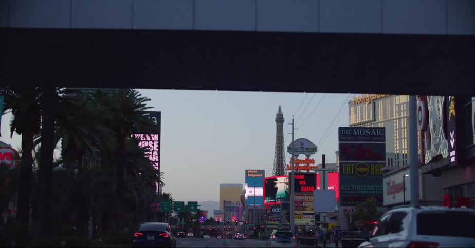 Pedestrians crossing an overpass over a street in las vegas at evening