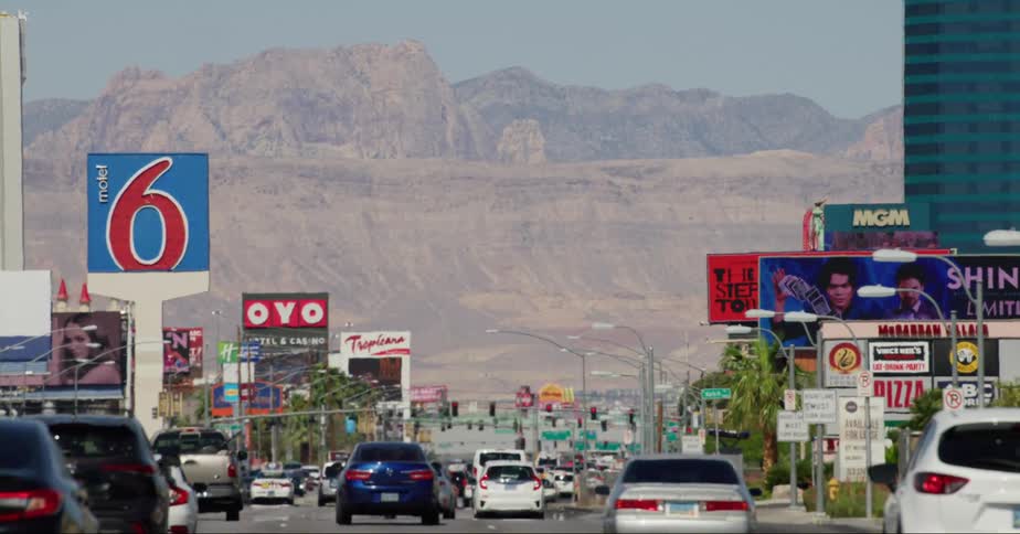 Vehicles driving on the streets of las vegas close to a mountain range