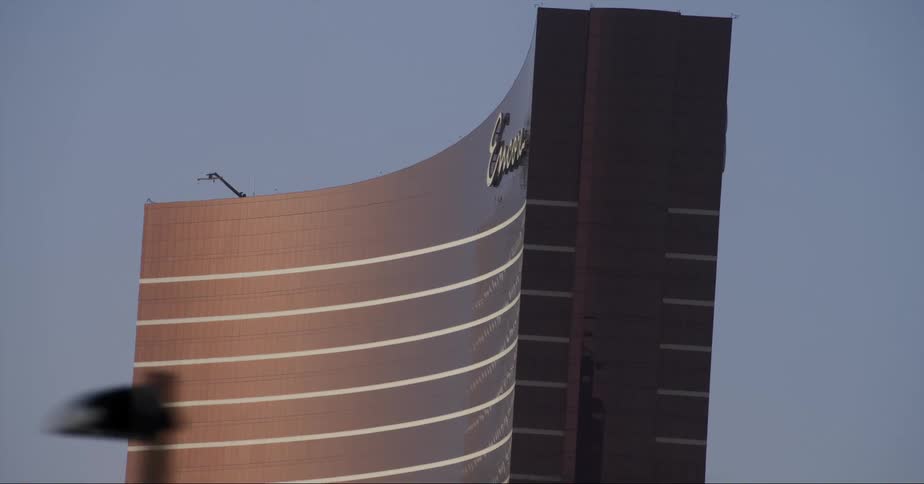 Vehicle with flashing blue lights passes near billboard near building in las vegas