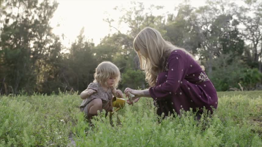 A mom and child plant seeds