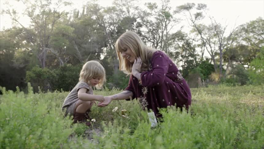 A woman and child play in a field