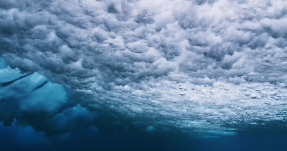Underwater footage of waves rolling overhead on the blue ocean waters