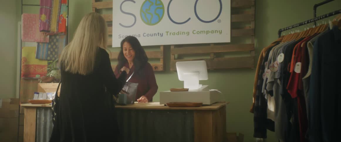 Woman shopping on a clothing stores brings a basket to the desk
