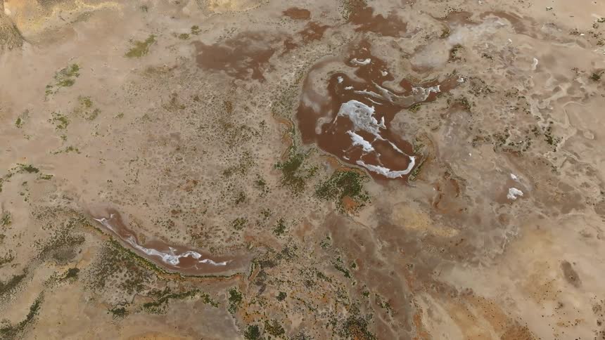 Aerial view of isolated pockets of water on a salty marsh