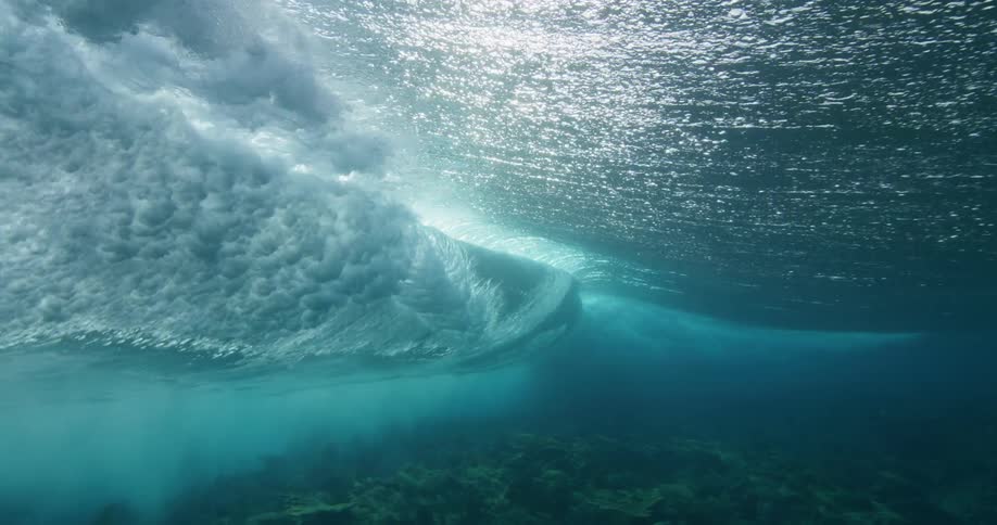 Water ripples and sparkles as sunlight shines on a wave moving over the seabed