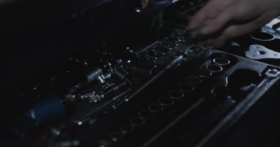 A man is putting tools away in his toolbox