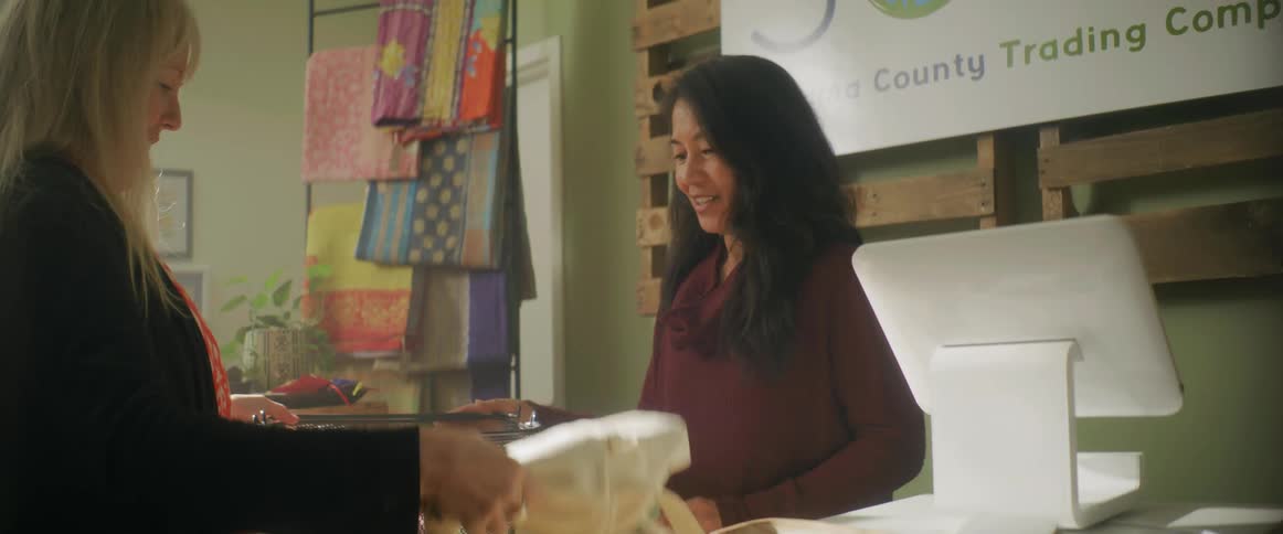 Cashier helps client to unload a basket full of items on the counter