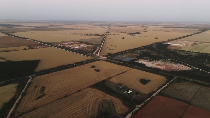 A vast rural countryside under a cloudy sky