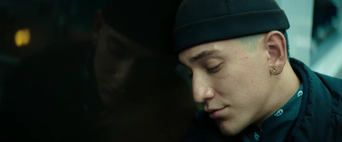 A young man is falling asleep riding a subway train