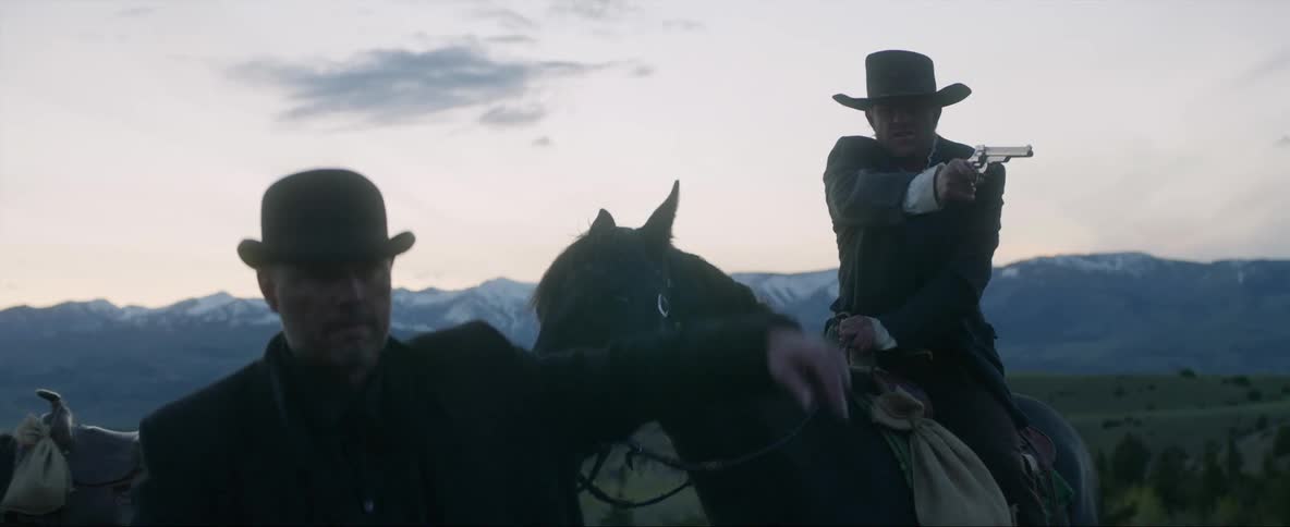 A couple of cowboys pointing their guns throw them away