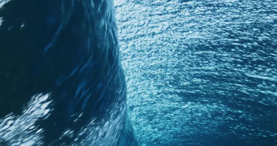 Large wave rolls up and crashes creating bubbles underwater