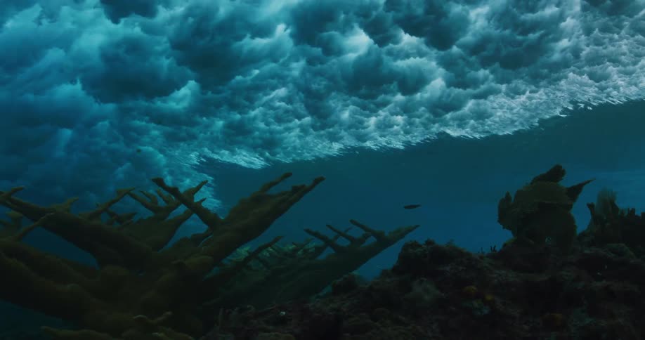 Underwater footage of waves rolling over coral reefs in the tropics