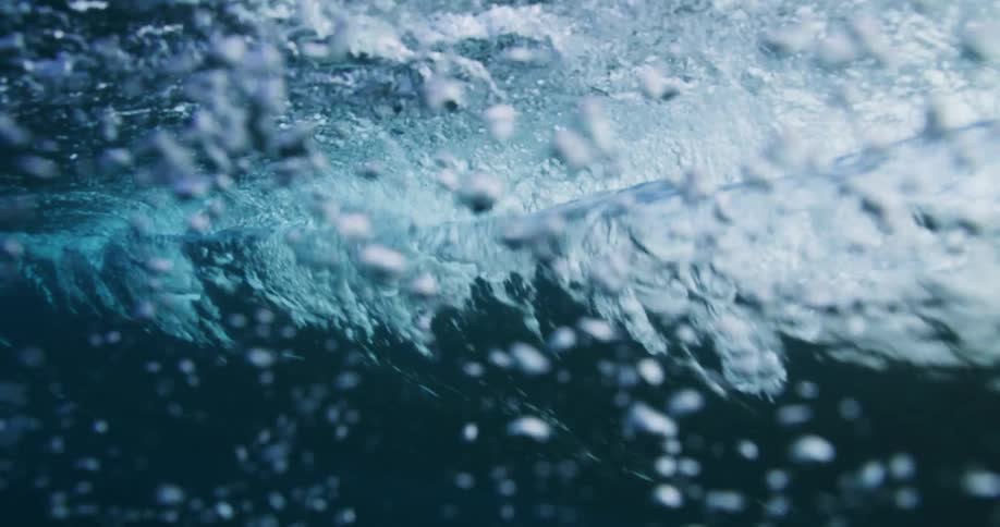 Underwater footage of waves rolling oververhead on the blue ocean waters
