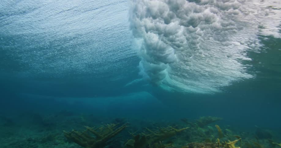 Underwater footage of waves rolling over coral reefs in the tropics
