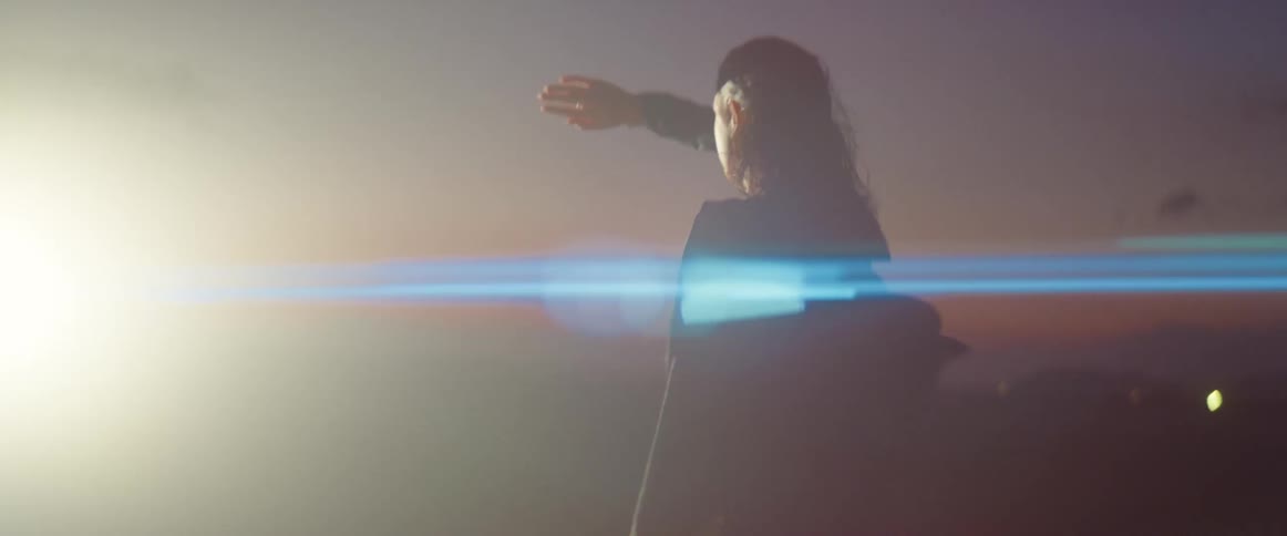 A woman is shielding her eyes and walking towards a bright light