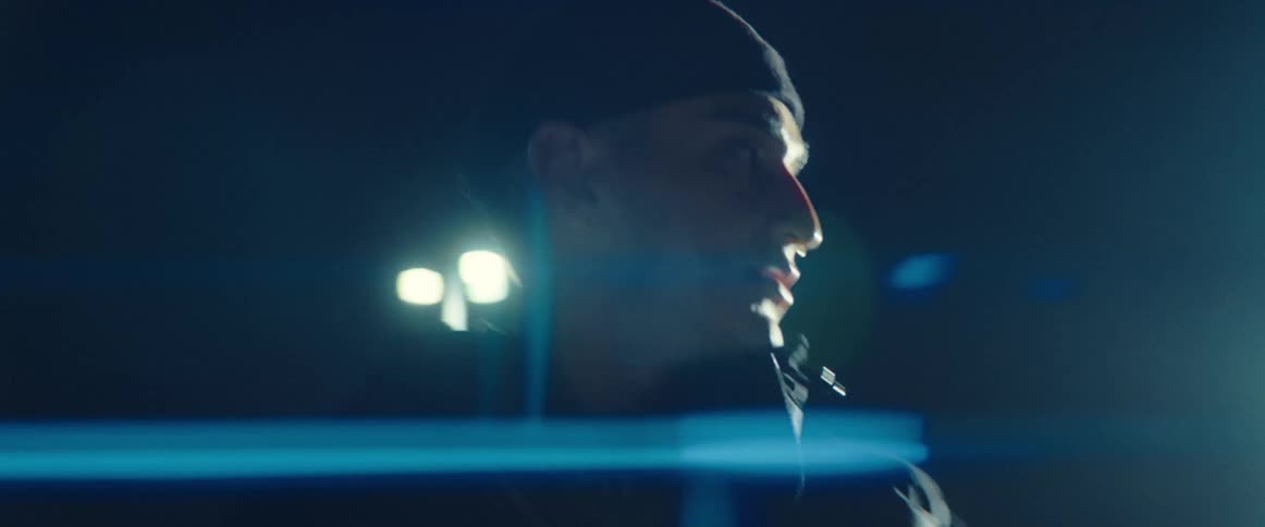 A man is standing in a downtown city during the night time