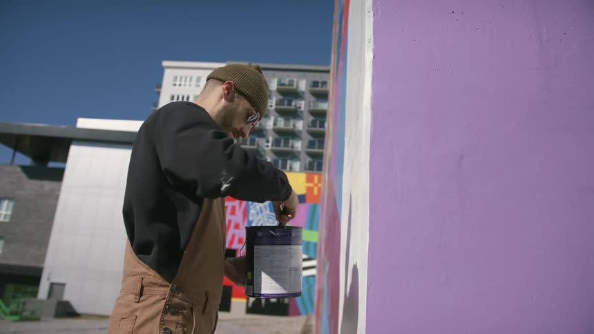 A man is painting a design on the building