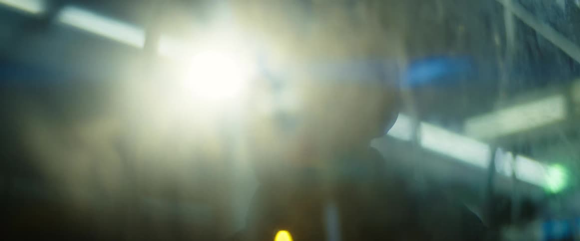 Close up of the face of a young man riding a bus in the city at night