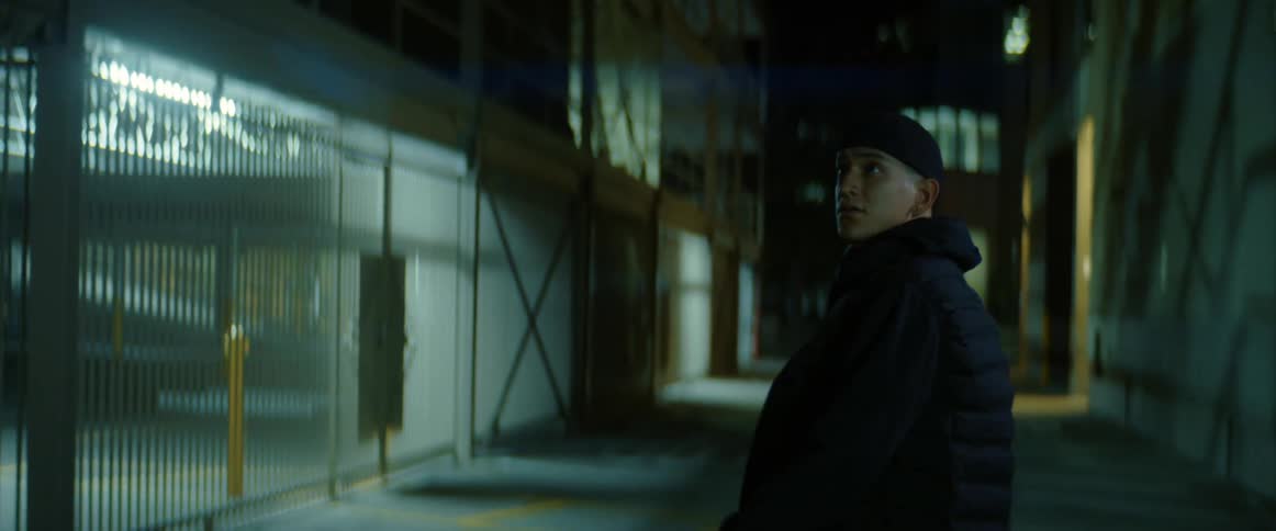 A man is walking down the alley at night