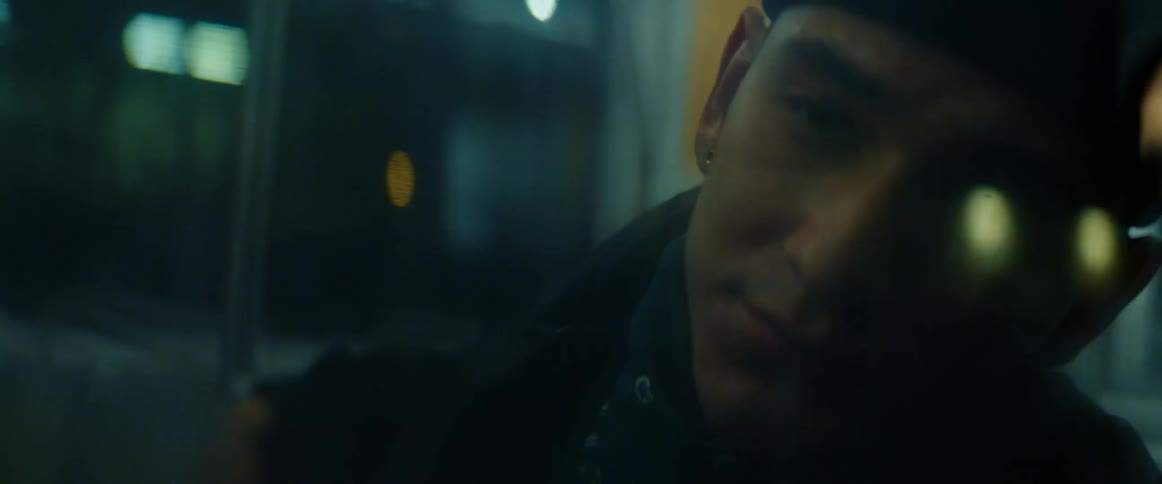 Man leans his head against reflective glass while riding public transportation at night