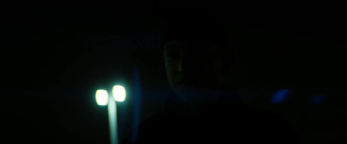 A man walks through a parking lot at night