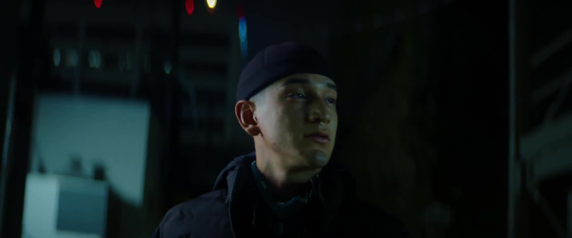 Man nervously walking on a dark alley in the city at night