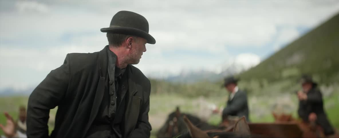 A group of outlaws robbing a man at gunpoint