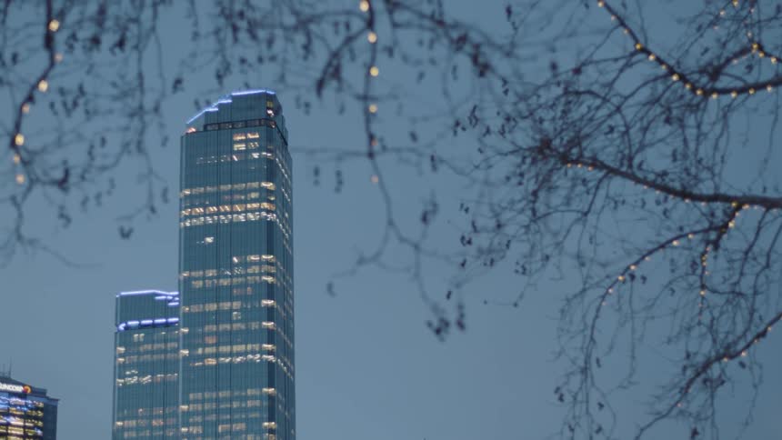 The building lights are visible at sunset in this city